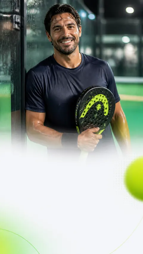 Ein lächelnder Padelspieler hält nach dem Match seinen Schläger vor dem Court.
